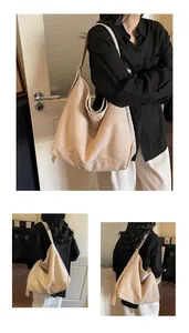 Detail view of large beige suede tote bag showing soft texture and wide shoulder strap