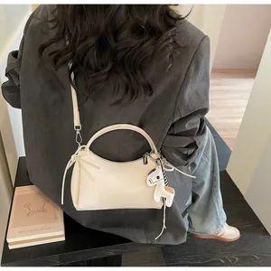 Close-up of minimalist off-white handbag with knotted leather and striped horse charm