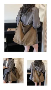 Detail of adjustable strap and bronze buckle on a brown suede large tote bag