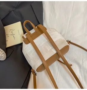 Detalle de mochila de lona y cuero marrón con hebillas metálicas y correas de hombro