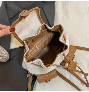 Detalle del interior de la mochila de lona con forro marrón y bolsillo con cremallera