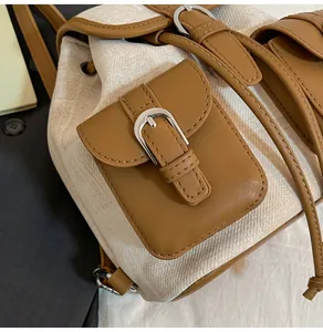 Detalle de la hebilla de cuero en la mochila retro de lona con acabados en marrón