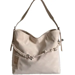 Minimalist beige oversized tote bag with decorative braided rope and smooth matte finish