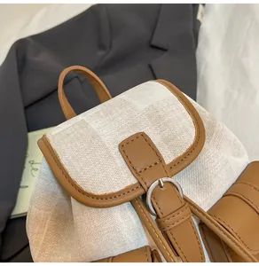 Primer plano de una mini mochila de lona beige con detalles de cuero marrón elegante