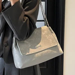 Sac fourre-tout gris chic à chaîne avec texture marbre et logo porté par un modèle