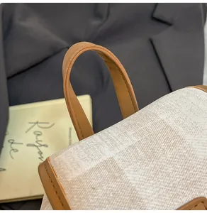 Detalle del asa de cuero marrón y tela a cuadros en una mochila con estilo moderno