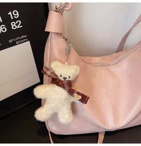 Pink faux leather tote bag detail with cute teddy bear charm and silver zipper finish
