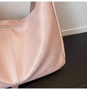 Close-up of pink leather tote bag showing high-quality double stitching and zipper detail