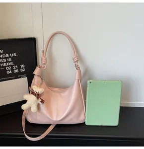 Pink hobo bag with knotted handle beside a 10-inch tablet showing large capacity