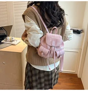 Detalle de mini mochila de tweed rosa con ribetes de cuero llevada por una modelo
