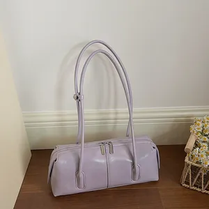 Minimalist light purple baguette shoulder bag with silver zipper on dark wood flooring