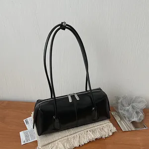 Minimalist black baguette shoulder bag in glossy leather with silver double zippers