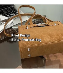 Detailed view of brown lychee leather handbag base with protective silver metal rivets