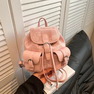 Mini mochila rosa de tela tejida con bolsillos frontales y correas ajustables en la mano