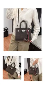 Detailed view of dark brown tote bag with silver turn-lock and dachshund charm accessory