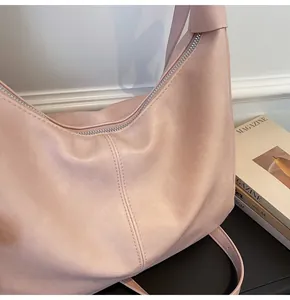 Detailed close-up of soft pink leather hobo bag with silver zipper and pebbled texture