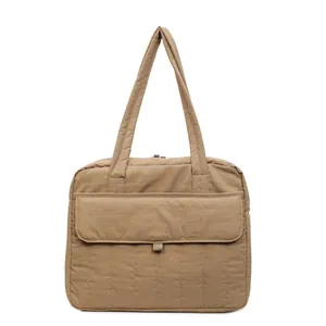 Detalle del bolso tote acolchado caqui con bolsillo frontal y textura de costura