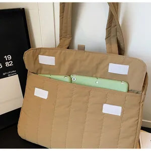 Detalle del bolso tote acolchado caqui con funda para portátil y cierre de velcro