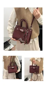 Detailed view of burgundy crossbody bag with silver lock and dachshund charm