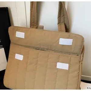 Detalle del bolso acolchado caqui con cierre de velcro y textura de tela rellena