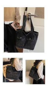 Detail of vintage black denim tote bag featuring dual front pockets and large capacity