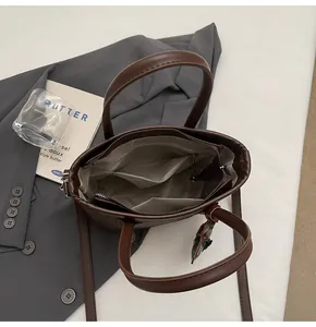 Vista superior del interior del bolso cubo marrón con compartimentos y bolsillos de cremallera