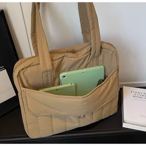Detalle de bolso tote acolchado caqui con bolsillo frontal para tabletas