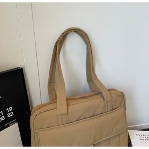 Detalle del bolso tote acolchado caqui con bolsillo frontal con solapa y cremallera