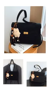 Detail view of black frosted leather tote bag with gold metal lock and plush star charm