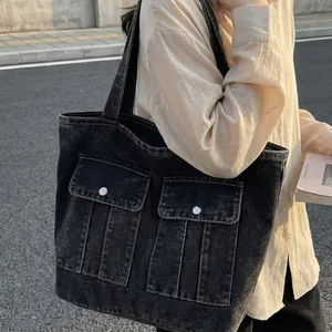 Vintage washed denim tote bag with cargo pockets shown in a street style street-side photo