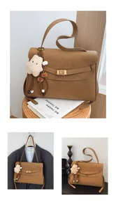 Detail of vintage matte brown tote bag with gold twist lock and plush bear charm
