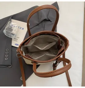 Vista superior del interior del bolso cubo con forro gris bolsillo y correa ajustable