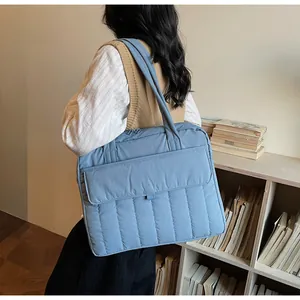 Primer plano de bolso tote acolchado azul claro con bolsillo frontal en una modelo
