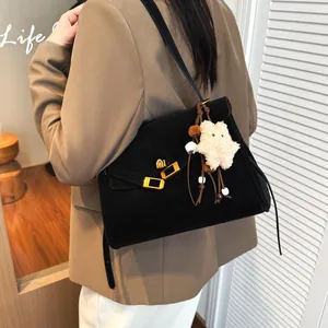Vintage matte black tote bag with gold buckle and star charm shown on a model
