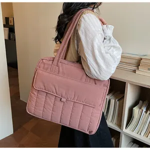 Vista detallada del bolso acolchado rosa para portátil con compartimentos y bolsillo frontal