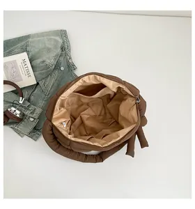 Dettaglio dell'interno della borsa trapuntata marrone con tasche e chiusura lampo