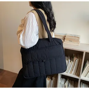 Bolso tote acolchado negro en modelo para mostrar el tamaño y la capacidad real