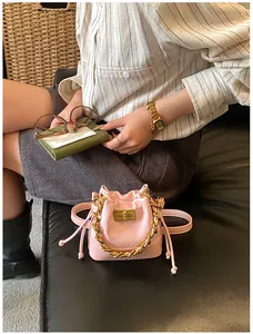 Détail du mini sac seau matelassé rose avec poignée chaîne dorée et fermeture à cordon