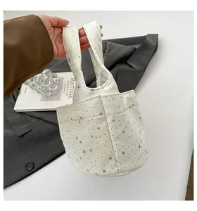 Dettaglio borsa tote in tela bianca con stampe di stelle argentate e tasca laterale