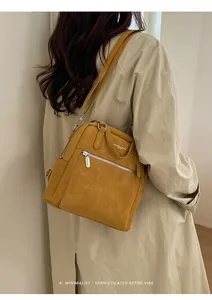 Nahaufnahme des senfgelben Vintage-Rucksacks mit Textprägung und silbernem Metallreißverschluss