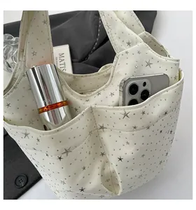 Dettaglio della borsa a secchiello in tela con stelle e tasca esterna porta cellulare