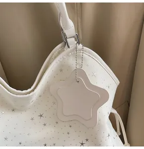 Gros plan d'un sac cabas crème avec étoiles argentées et une étiquette en étoile
