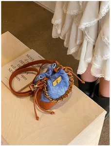 Détails du mini sac seau en denim avec motifs matelassés et chaîne en métal doré