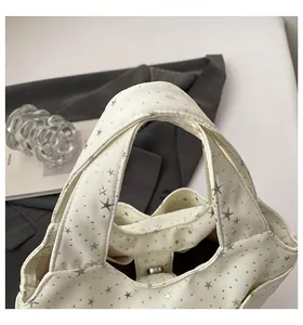 Dettaglio della borsa tote in tela con stelle argentate e chiusura magnetica