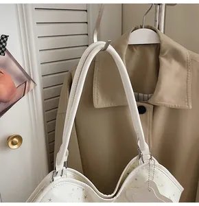 Détail du sac cabas blanc à motifs étoiles, double anse et breloque étoile