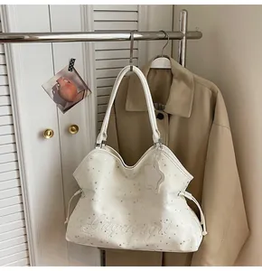 Détail du sac cabas blanc avec broderie d'étoiles argentées et bordure ondulée chic