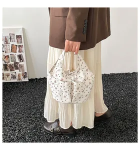 Borsa a secchiello in tela trapuntata con stampe di orsi mostrata in uno scatto moda