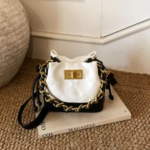 Détail du sac seau matelassé bicolore noir et blanc avec fermoir tournant doré élégant