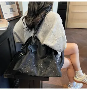 Détail du sac cabas noir à motifs d'étoiles avec une broderie de lettres en relief en 3D