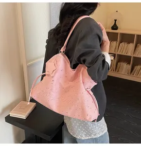 Détail d'un sac cabas rose à motif d'étoiles avec pendentif étoile et cordon latéral